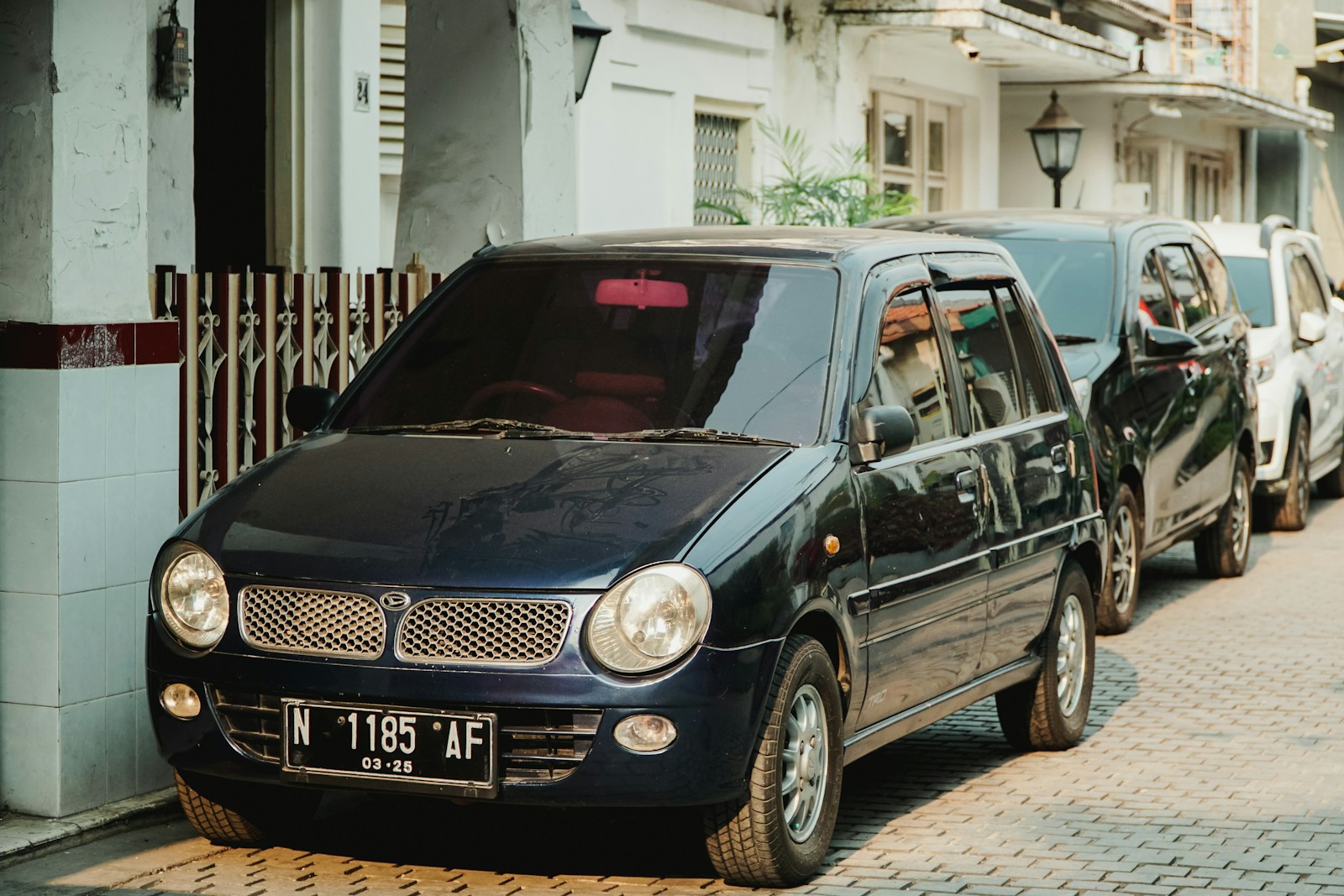 a blue car parked on the side of a street